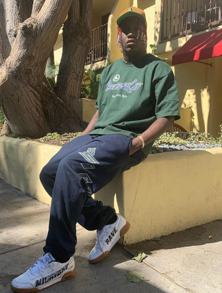 Lil Yachty sitting wearing white sneakers