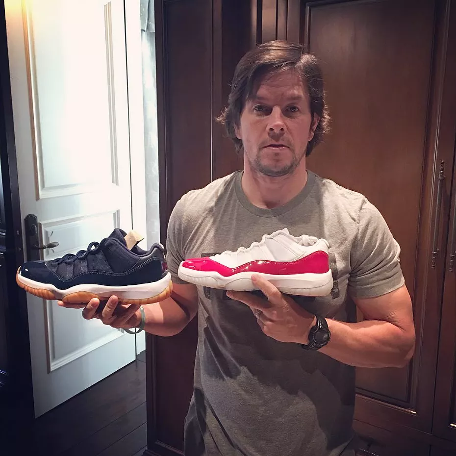 Mark Wahlberg holding sneakers at his house