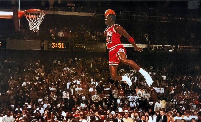Michael Jordan flying to dunk in the basketball stadium
