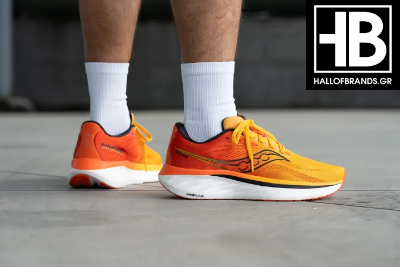 Τα ανδρικά αθλητικά running shoes Saucony Ride 18 σε πορτοκαλί χρώμα, φορεμένα σε ανδρικά πόδια
